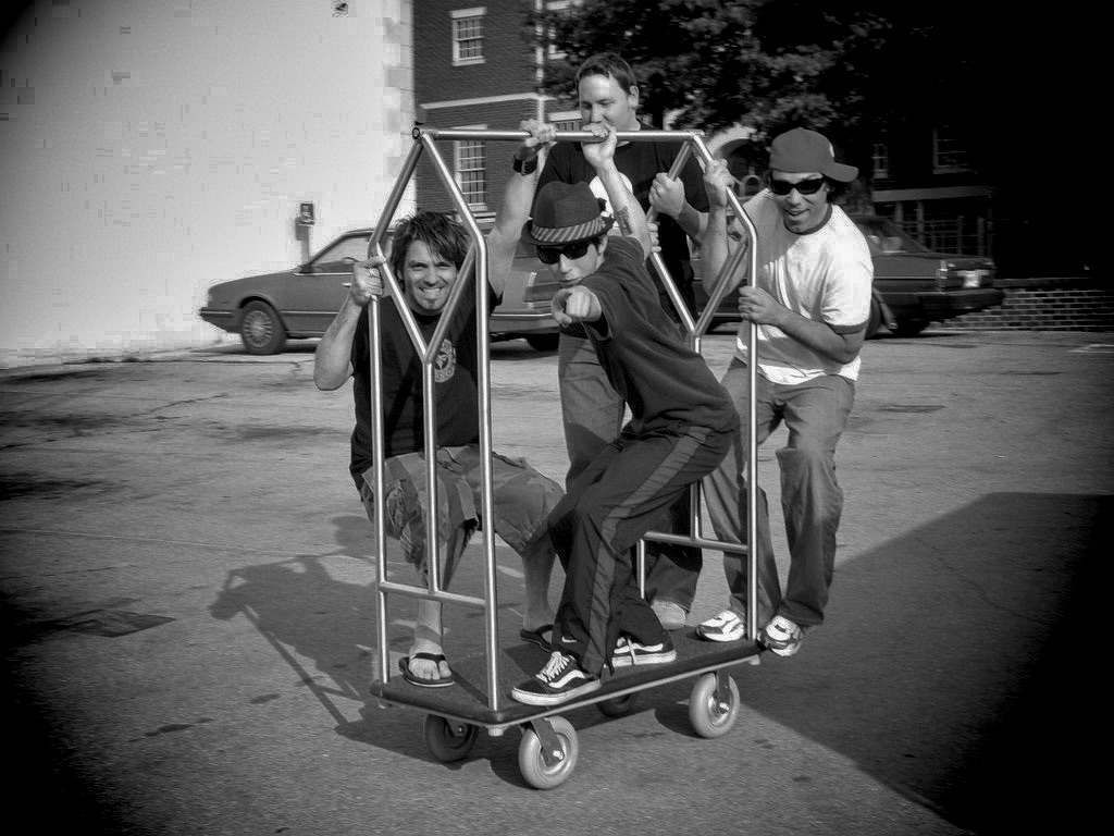 The Jackie Greene band together with a hotel luggage cart in an early 2006 photograph
