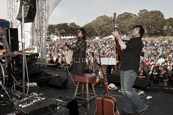 Jackie Greene and Nathan Dale cueing substitute drummer Prairie Prince during the 2010 San Francisco Oyster Festival at Fort Mason