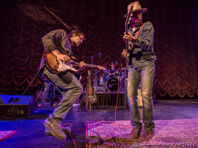 Nathan Dale and Jackie Greene leaning into a guitar exchange with Fitz Harris on drums at the Crest Theatre in 2015