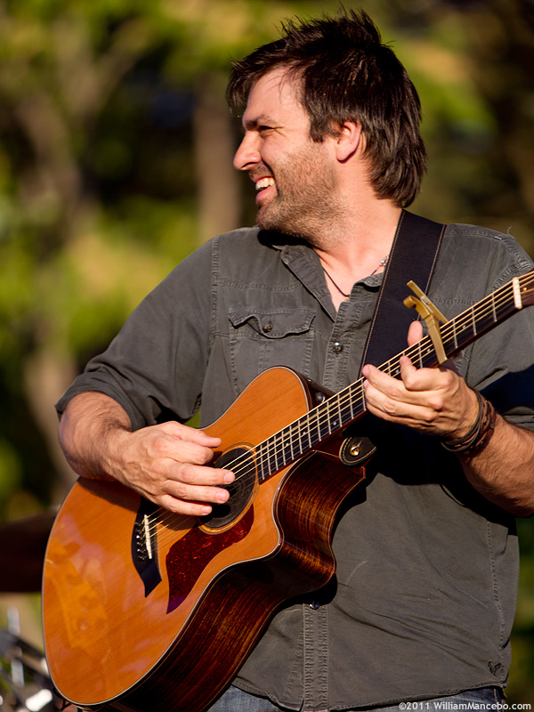 Nathan Dale playing acoustic guitar during a solo performance in 2011