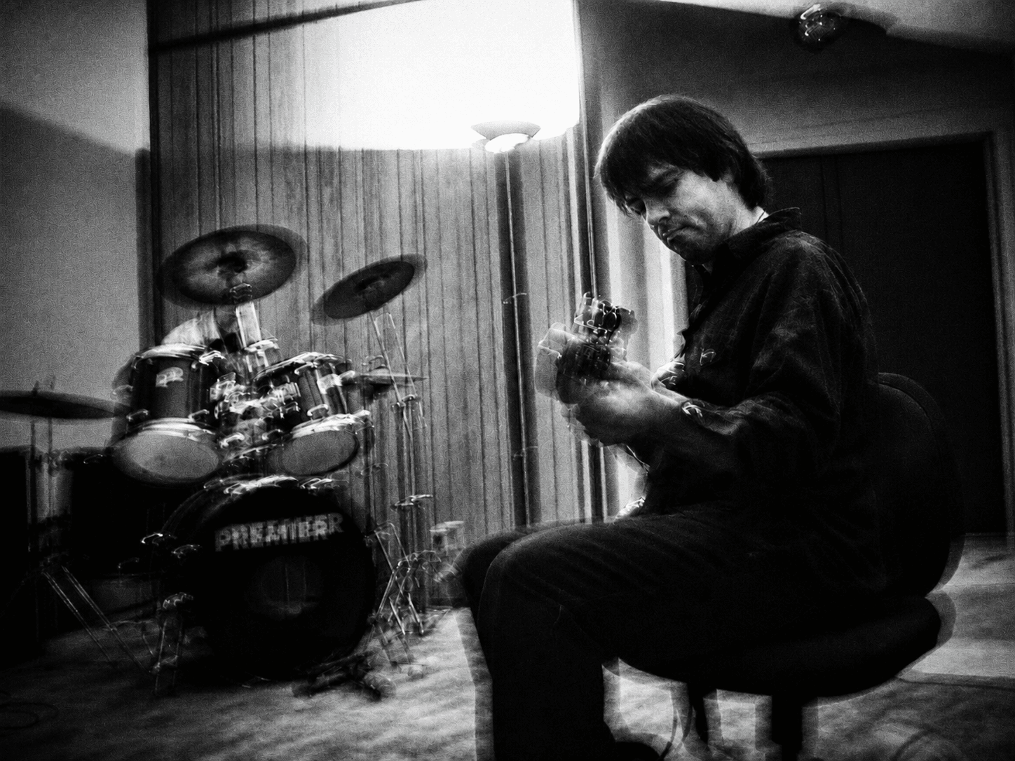 Nathan Dale playing bass while Jeremy Plog plays drums in Jeremy's unfurnished living room on January 1, 2000