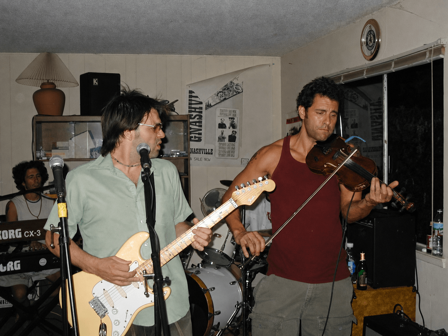Nathan Dale playing guitar beside Mind X multi-instrumentalist Sean Barfly on fiddle