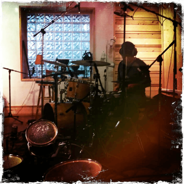 Bruce Spencer playing drums in the live room at The Harm Farm recording studio
